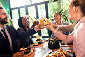 Group of businesspeople in a restaurant toasting at business lunch.