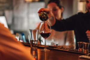 bartender-pouring-wine-in-a-wine-glass-in-a-bar-2023-11-27-05-03-09-utc