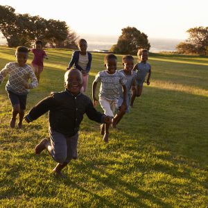 African elementary school kids running to camera in a field