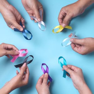 multi-color-ribbons-on-hands-isolated-on-blue-can-2023-11-27-05-19-42-utc