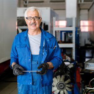 Successful mature owner of machine repair service with tablet looking at you