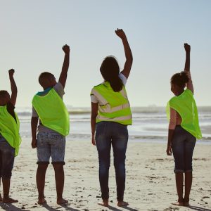 Teamwork, recycle and hands of volunteer at the beach for cleaning, recycling and earth day. Commun